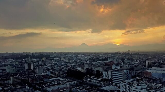 Drone aerial view. Beautiful view of a sunset over Guatemala City. Silhouettes of mountains and volcanoes emerge on the horizon.