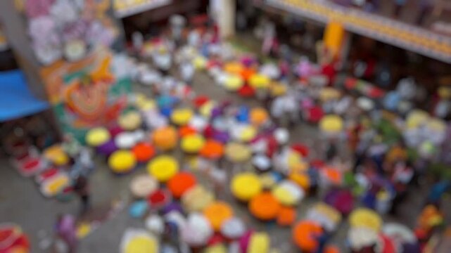Bokeh view of flower sellers and their customers at colorful KR Market in Bangalore, India. Blurred background footage.