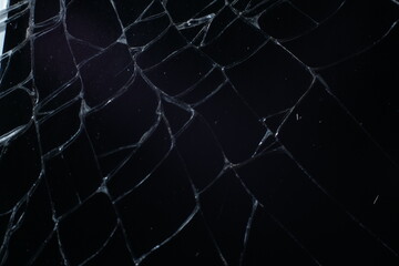 Glass broken into a large number of shards and cracks, a piece of glass with a large number of cracks and broken parts