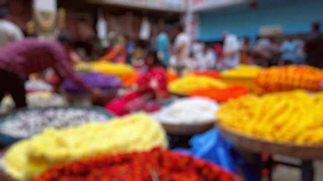 Bokeh view of flower sellers and their customers at colorful KR Market in Bangalore, India. Blurred background footage.
