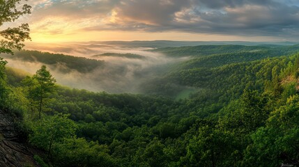 Obraz premium Foggy mountain range with a beautiful sunrise in the background