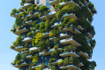 Modern building showcases vertical garden covered in diverse greenery, blending architecture with nature for sustainable living.