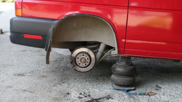 Car service on a red vehicle with missing wheel