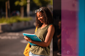 Teenage student studying outdoors with school supplies