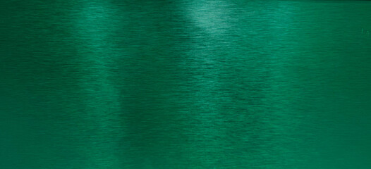 Brushed dark green metal texture with horizontal grain and subtle reflections, ideal for backgrounds, luxurious designs, and industrial aesthetics.