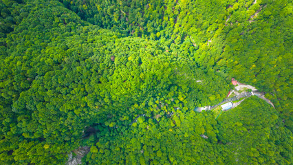 Aerial view of Skrad town and Zeleni Vir area in Gorski Kotar, Croatia. Scenic mountain landscape with green forest, winding roads, and scattered houses in lush nature