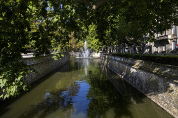 Fototapeta premium Les Quais de la Fontaine leading to the Jardins de la Fontaine in the centre of Nimes France
