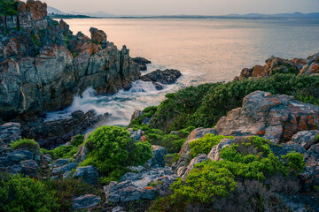 Coastal vegetation and rugged rocks frame Walker Bay’s shoreline in Hermanus, Western Cape. A scenic, unspoiled view of the Whale Coast’s dramatic geology and natural marine beauty.