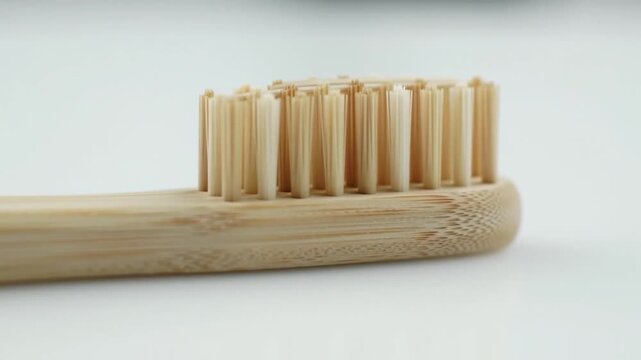 A simple bamboo toothbrush on a white background.