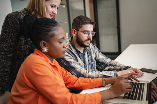 Group of People Sitting Around a Laptop Computer