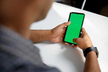 Cropped shot man using mockup mobile phone with green screen montage.
