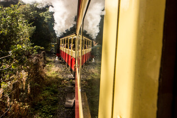 The Vale of Rheidol steam train reflecting in itself as it goes along a curve