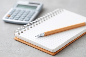 Notepad and pencil on clean surface alongside calculator, perfec