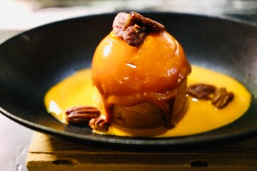 Gourmet caramel sphere dessert with pecans