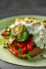 Baked sweet potato topped with fresh salad, yogurt and peanuts