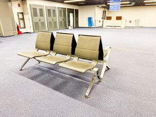 Empty airport waiting area with plastic seating and clean carpeted floor. Travel infrastructure, modern public space, and calmness before boarding.