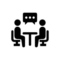 Two people sitting at a table discussing ideas with a speech bubble icon
