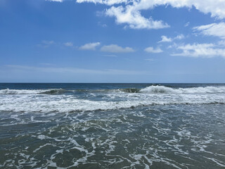 Waves gently crashing on the quiet beach under a clear blue sky in Cuyagua, Venezuela
