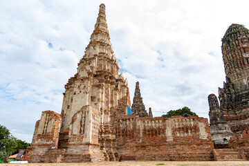 Fototapeta premium Weathered spire of Wat Chaiwatthanaram temple in Ayutthaya, Thailand captured against a bright cloudy sky