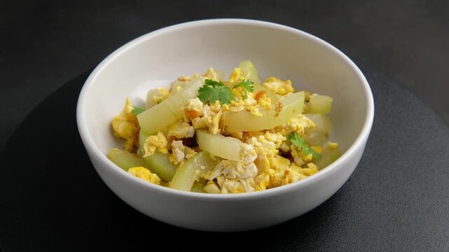 Stir Fried Winter Melon with Egg in white bowl.