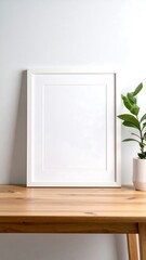 White frame on a wooden table with plant