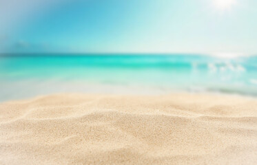 Obraz na płótnie Canvas Minimalist summer composition of warm golden beach sand with natural space for product placement or text overlay. Blue sky, sunlight and sea view with creative marketing summer vacation concept.