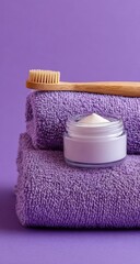 Purple towels, bamboo toothbrush, and cream jar