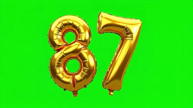 Shiny gold foil number balloons '87' float against a vibrant green screen background, perfect for celebrations