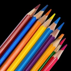 Fototapeta premium A vibrant array of sharpened colored pencils fanned out against a stark black background, showcasing a spectrum of hues