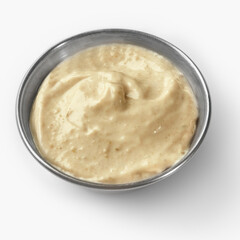 Creamy tahini sauce in a small metal bowl on white background