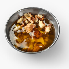 Walnut pieces floating in a bowl of golden honey