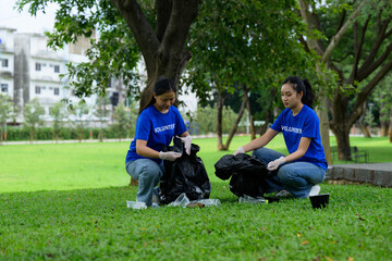 Fototapeta premium Volunteers picking up trash in park wearing blue shirts and gloves
