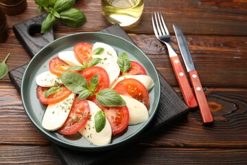 Tasty salad Caprese served on wooden table, closeup