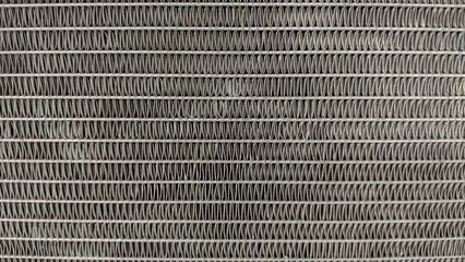 Abstract metal texture background of tightly packed air conditioner fins, creating a repetitive and...