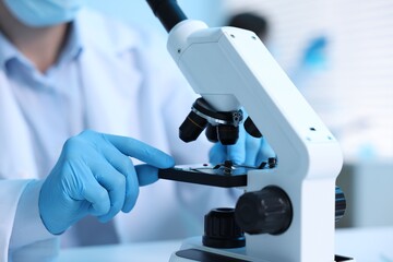 Medical analysis. Scientist working with microscope in laboratory, selective focus