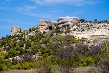 Fototapeta premium View of the mountain wall from the cave against the sky.