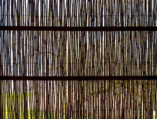 The wall in the gazebo is made of wooden rods.