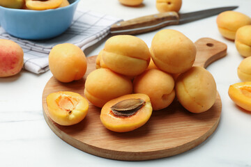 Fresh ripe apricots on white marble table, closeup