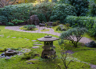 A serene Japanese garden featuring a traditional stone lantern amidst a lush carpet of green moss,...