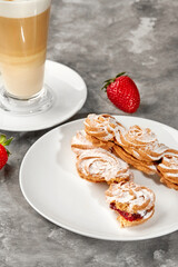 Kurabye cookies with strawberry filling served with latte and strawberries on gray background