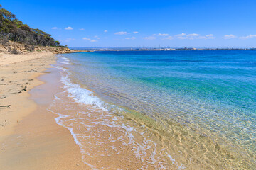 Obraz premium Cheradi Islands: view of San Pietro Island in Apulia, Italy. In the distance the skyline of the city of Taranto.