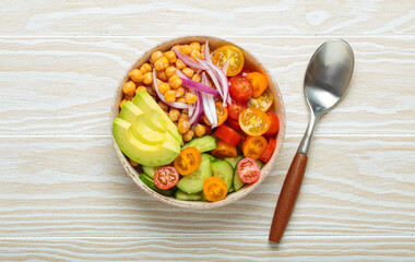 Healthy chickpea salad with ripe avocado, juicy cherry tomatoes, crisp cucumber, and red onion slices. Perfect for a nutritious and healthy meal