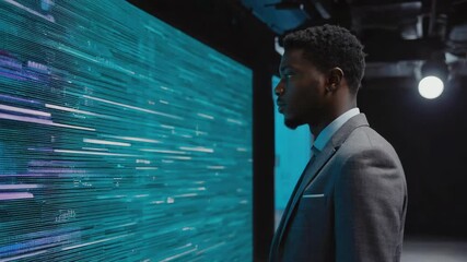 Businessman standing in profile, observing a large digital display filled with big data, illustrating data analysis and business intelligence in a high-tech environment - Powered by Adobe