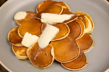 a large pile of round pancakes with butter made from milk after cooking, hot pancakes with butter that melts