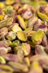 pistachios crushed into pieces of different sizes, a bunch of green pistachios