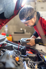 Technician checks oil level in car engine using oil dipstick in garage. Engine service check, oil refilling and changing in service. Engine problems, engine repair and battery in car service.