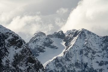 Obraz premium Sunlight and shadow create dramatic contrast on the jagged, snow-covered peaks and glaciers of the high Alps. Picture taken on a holiday trip to Les 2 Alpes, France with my Sony a7III