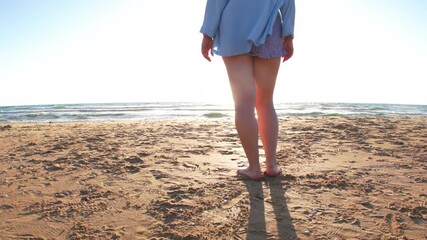 Girl on the beach at sunset. Plus size model. Girl enjoying her body and not considering herself fat. Summer mood.