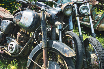 Obraz premium Rusty Vintage Motorcycles Abandoned in Grass – Soviet Era Classics
