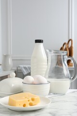 Different dairy products and eggs on white marble table indoors